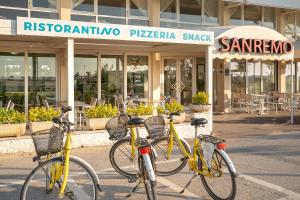 three bikes parked in front of a restaurant at Hotel Sanremo in Caorle
