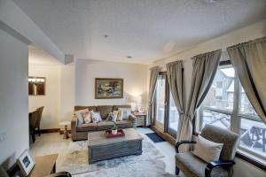a living room with a couch and a table at Fire Mountain 204 2 Level, 2 bed, great views! in Canmore