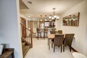 a dining room and kitchen with a table and chairs at Fire Mountain 204 2 Level, 2 bed, great views! in Canmore