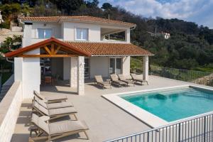 a villa with a swimming pool and a house at NEW! Villa Rabella - Luxury Oasis, Island Rab in Rab