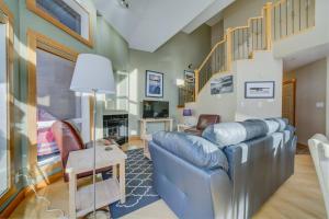 a living room with a blue couch and stairs at 212 Alpine Village Spacious 2Bed-2Bath-Mtn Views! in Canmore