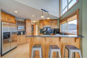 a kitchen with wooden cabinets and a counter with stools at 212 Alpine Village Spacious 2Bed-2Bath-Mtn Views! in Canmore