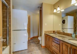 a bathroom with a refrigerator and a sink and a toilet at 212 Alpine Village Spacious 2Bed-2Bath-Mtn Views! in Canmore