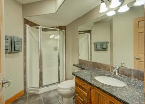 a bathroom with a shower and a toilet and a sink at 212 Alpine Village Spacious 2Bed-2Bath-Mtn Views! in Canmore +9 photos