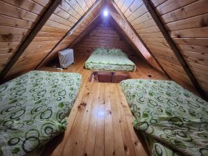 a room with two beds and a wooden floor at Kraljeva breza in Divčibare
