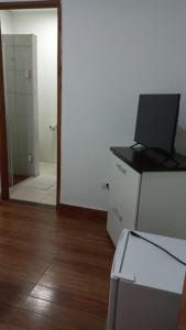 a room with a laptop on a desk and a mirror at Hotel Pousada Bortolan in Poços de Caldas