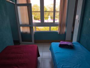 a room with two beds and a window at GuateDo Atitlán Loft & Rooftop in Panajachel