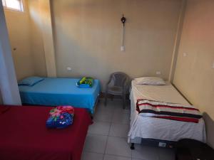 a room with two beds and a chair in it at GuateDo Atitlán Loft & Rooftop in Panajachel