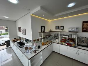 a kitchen with a counter with food on it at Pousada Molhes da Barra in Torres