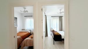 a white room with two beds and a room with two beds at TarifaMiCasa Mar Tirreno in Tarifa