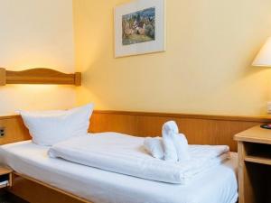 a hotel room with a bed with towels on it at Hotel Restaurant Bären in Weingarten