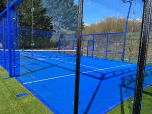 ein Tennisplatz mit blauer Farbe darauf in der Unterkunft Les Orchidées , Hôtel & Restaurant in Verdun-sur-Meuse