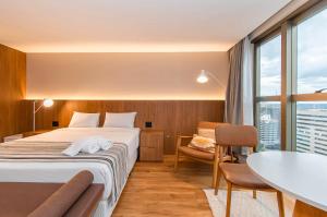 a hotel room with a bed and a table at Brasil 21 Bloco D Flat em Brasília 80760 in Brasília