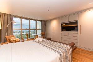 a bedroom with a large bed and a large window at Brasil 21 Bloco D Flat em Brasília 80760 in Brasília