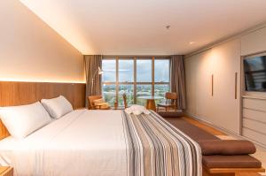 a hotel room with a bed and a large window at Brasil 21 Bloco D Flat em Brasília 80760 in Brasília