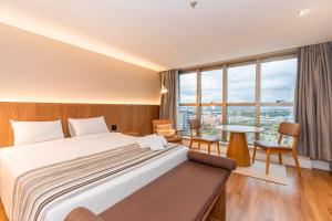 a hotel room with a bed and a table and chairs at Brasil 21 Bloco D Flat em Brasília 80760 in Brasília +20 photos