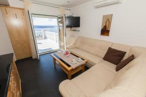 a living room with a white couch and a table at Apartment Crikvenica 5 in Sopaljska