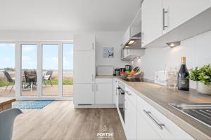a kitchen with white cabinets and a view of a patio at Ferienwohnung Albatros Olpenitz in Olpenitz