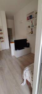 a white living room with a flat screen tv at Casa Martina in Cogoleto