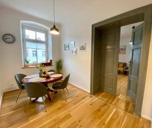 a dining room with a table and chairs and a window at Apartament Pod Tężnią in Głuchołazy