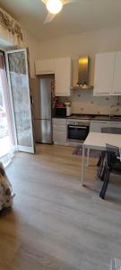a kitchen with a white table and a kitchen with a counter at Casa Martina in Cogoleto +3 photos