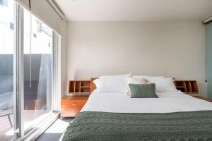 a bedroom with a large bed and a large window at Chic 2BR Condo in Condesa steps from Parque Mexico in Mexico City