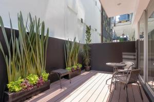 a balcony with a table and chairs and plants at Chic 2BR Condo in Condesa steps from Parque Mexico in Mexico City +21 photos