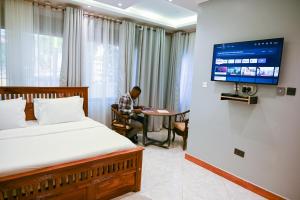 a man sitting at a table in a hotel room at Neon Hotel in Kampala