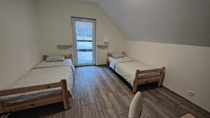 two twin beds in a room with a window at Agrowinnica in Borzytuchom