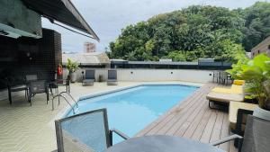 a swimming pool on a patio with a table and chairs at Studio apartment in downtown Joinville, SC in Joinville
