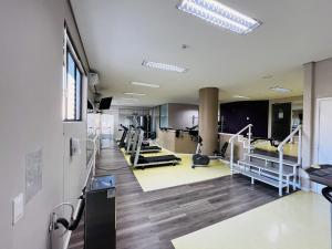 a gym with treadmills and elliptical machines at Studio apartment in downtown Joinville, SC in Joinville