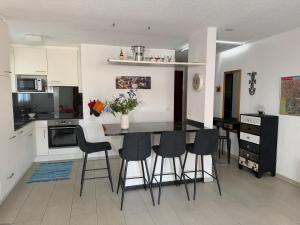 a kitchen with a table and chairs in a room at Onyx - 1 5 Zimmer in Muralto