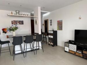 a living room with a table and chairs and a television at Onyx - 1 5 Zimmer in Muralto