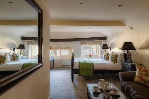 a room with two beds and a mirror at The Wensleydale Hotel in Middleham