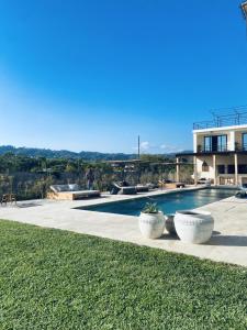 a villa with a swimming pool and a house at Selvamar Hermosa in Playa Hermosa