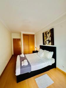 a bedroom with a large bed with two pillows on it at Renaissance sunrises inn in Portimão