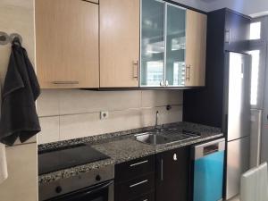 a kitchen with wooden cabinets and a sink at Renaissance sunrises inn in Portimão