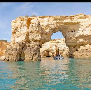 a boat in the water in front of a rock formation at Renaissance sunrises inn in Portimão +6 photos
