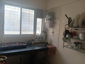 a kitchen with a sink and a window at Akshara Ac 1 bhk in Hinjewadi