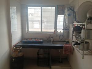 a small kitchen with a sink and a window at Akshara Ac 1 bhk in Hinjewadi
