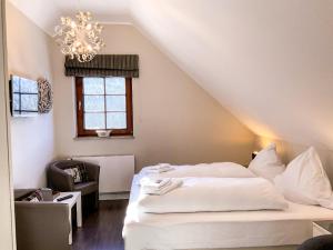 a bedroom with a white bed and a chandelier at Luxus Ferienwohnung schöne Aussicht in Hahnenklee-Bockswiese