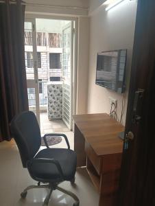a desk and a chair in a room with a window at Akshara Ac 1 bhk in Hinjewadi