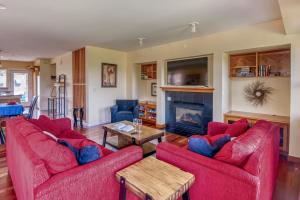 a living room with two red couches and a fireplace at Lakeside Haven in Rockaway Beach