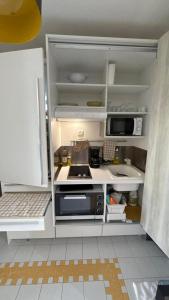 a small kitchen with a stove and a microwave at La Casa Manao - Charmant Studio SF in Saint-François