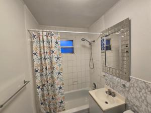 a bathroom with a shower curtain and a sink at Brossard home2 in Brossard