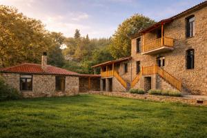 ein altes Steinhaus mit Balkon und Hof in der Unterkunft Kanalia Suites in Kanália