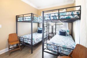 a bedroom with two bunk beds and a chair at Sand N Surf in Folly Beach +46 photos