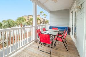a patio with red chairs and a table on a balcony at Sand N Surf in Folly Beach