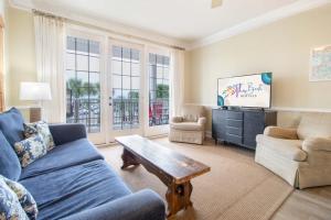 a living room with a blue couch and a coffee table at Sand N Surf in Folly Beach