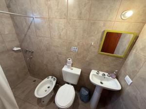 a small bathroom with a toilet and a sink at Alojamiento Caroya in Colonia Caroya +16 photos